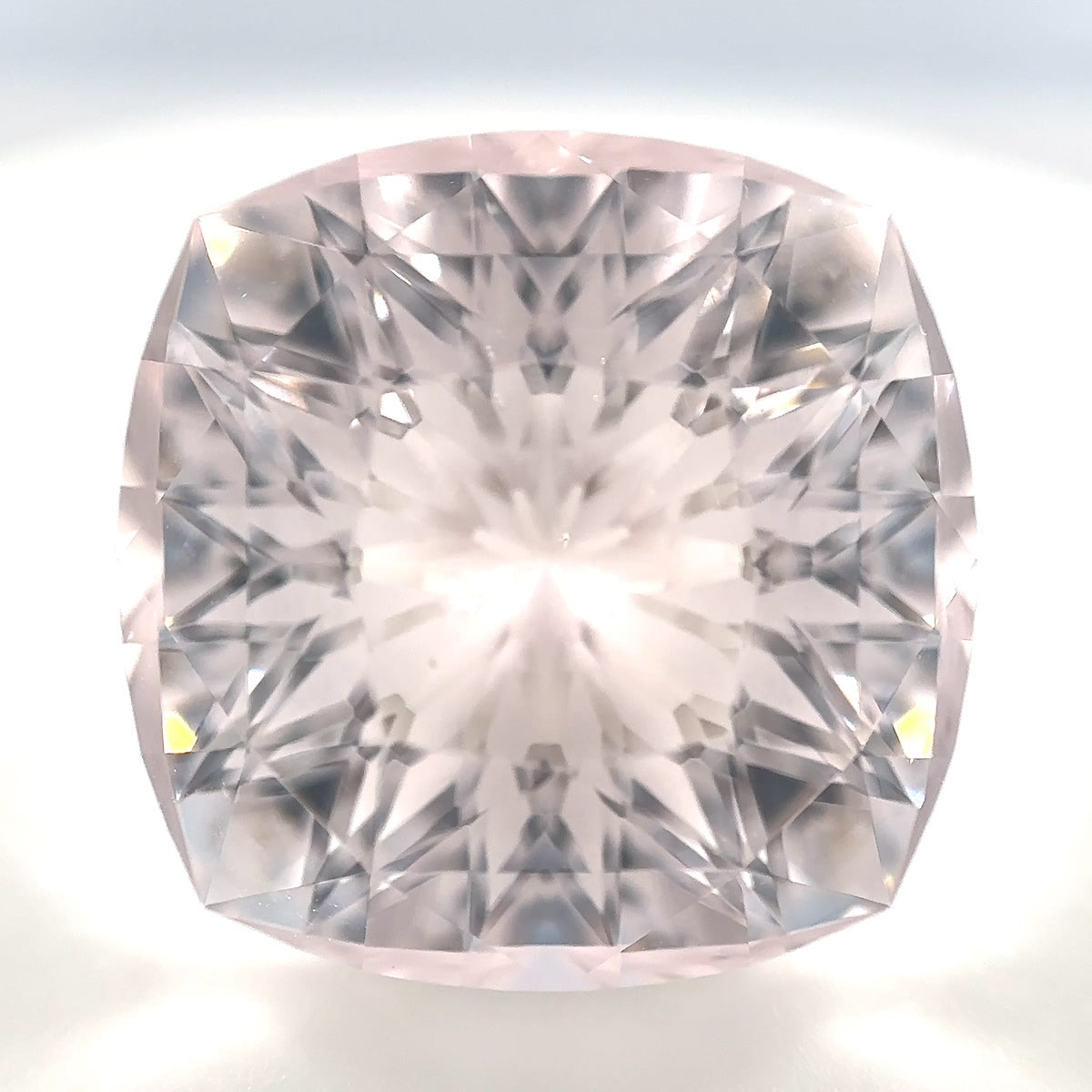 Makroaufnahme eines 31.44 Karat Morganit Edelsteins in zartem Pastell-Rosa. Der einzigartige Artist Phantasy Cut im Kissen-Schliff zeigt seltene, satinierte Facetten. Handselektiertes Unikat aus Pakistan.